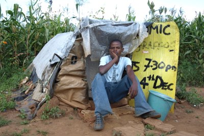 A man sits outside his home in Gunhill informal settlement, Zimbabwe.