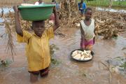 Children recover maize from a flooded field in Uganda. Climate change threatens regional development in Africa.