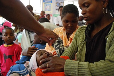A mother holds her baby as they receive the polio vaccination.
