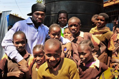 Rapper Curtis '50 Cent' Jackson with school kids in a Nairobi slum.