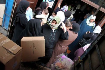 Syrian refugees receive supplies from UNHCR in northern Lebanon.