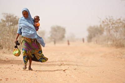 A woman and her severely malnourished son leave a UNICEF-supported health centre, in Maradi Region, Mali.