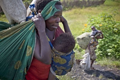 A woman and her family flee ongoing fighting between M23 rebels and government forces outside Sake, near Goma in the Democratic Republic of Congo.