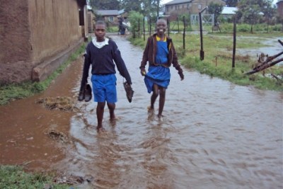 Children walk on submerged foot paths (file photo).