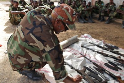 A senior officer inspects weapons dismantled by soldiers of the Somali National Army as part of a weapons drill at the Gashandiga barracks in Mogadishu, Somalia. (file photo)
