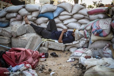 A supporter of Egypt's ousted President Mohammed Morsi sleeps by sand barriers set up by protesters (file photo).