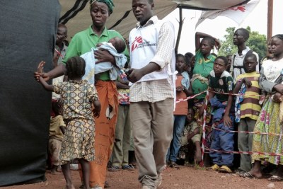 Un agent de MSF assiste une mère de famille