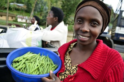A farmer with her bean harvest in Rwanda.