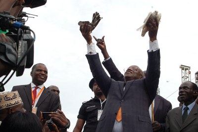 Amama Mbabazi releasing 'peace' doves into the air at Nakivubo stadium
