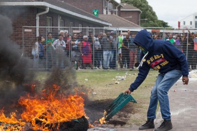 A protesting UWC student sets a tyre alight (file photo).