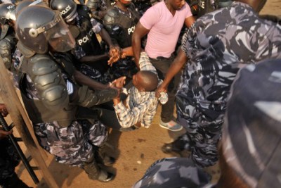 Présidentielle : Un des partisans de  Kizza Besigye, candidat de l'opposition, est traîné par la police à Wandegeya à Kampala .
