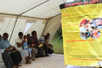 People wait at a mobile clinic to be screened for typhoid in Harare.