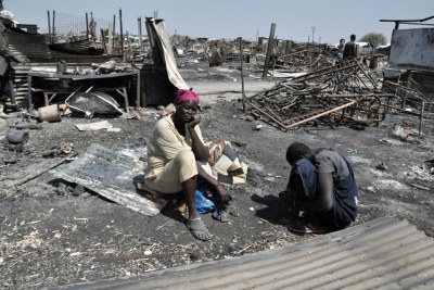 Des femmes déplacées sont assises sur les cendres de leur abri qui a été brûlé pendant des combats et incendies, les 17 et 18 février 2016, dans le site de protection des civils de l’ONU à Malakal, au Soudan du Sud.