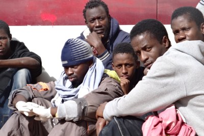 Des migrants à l'extérieur d'un centre de détention