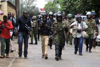 Journalists take cover behind police officers during Cord’s anti-IEBC demonstrations on May 23, 2016.