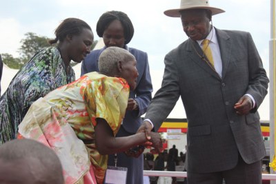 President Yoweri Museveni supports an elderly Nalubaale medal recipient during Heroes' Day celebrations in 2013.