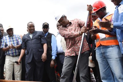 Kenyan President Uhuru Kenyatta (3rd R, front) tightens the screw during his inspection of a construction site of the Standard Gauge Railway (SGR) project near Sultan Halmud.