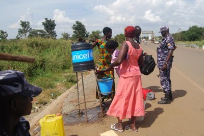 Women from South Sudan sanitise hands