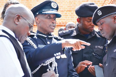 IGP Kale Kayihura chats with some police officers at Lubaga cathedral recently