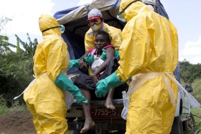 Health workers assist a patient suspected of having Ebola (file photo).