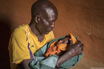 Nachadee Lokwabong, 50, holds his one-week-old son Enoch Rofich for the first time at home in the Amudat district of Karamoja, Uganda, 15 March 2017. “I am happy,” says Nachadee as he looks down at his newborn son and strokes his cheek.