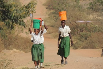 Some of the girls carrying buckets of water to school.