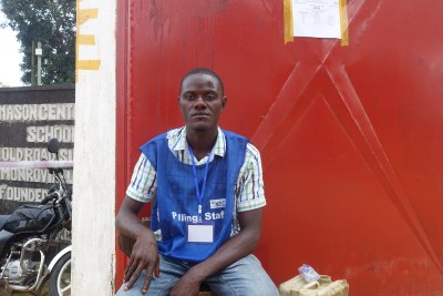 A worker of the National Elections Commission sits at the entrance of a polling precinct.