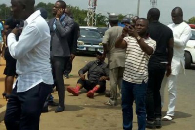 Senator Dino Melaye, sitting on the floor after jumping out of a moving police van.
