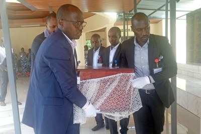Pallbearers carry a casket containing remaims of 13 victims of the Genocide against the Tutsi for a decent burial. They were killed at the Rwanda Agriculture Research Institute.