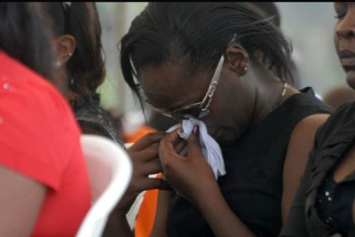 A woman cries out in sorrow during a memorial Mass at Kyadondo Rugby grounds in Kampala on Jul 11, 2011 (file photo).