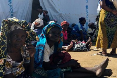 Women sit outside a UNICEF tent in Mozambique.