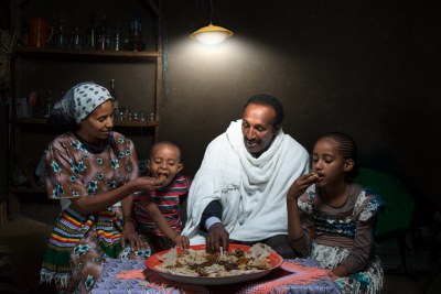 An Ethiopian family enjoys a meal with the help of a Sun King home system