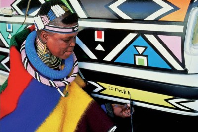 Esther Mahlangu doing Ndebele culture paintings.