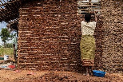 At the Mapupulu site for internally displaced persons a woman is seen patting mud into the frame of the hut her family is building after having fled the armed conflict happening in Northern Mozambique, Cabo Delgado province (file photo).