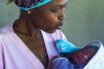 Sage-femme, tient dans ses bras un bébé qu'elle vient d'accoucher à l'hôpital de Nioumachoua, sur l'île de Mohéli.